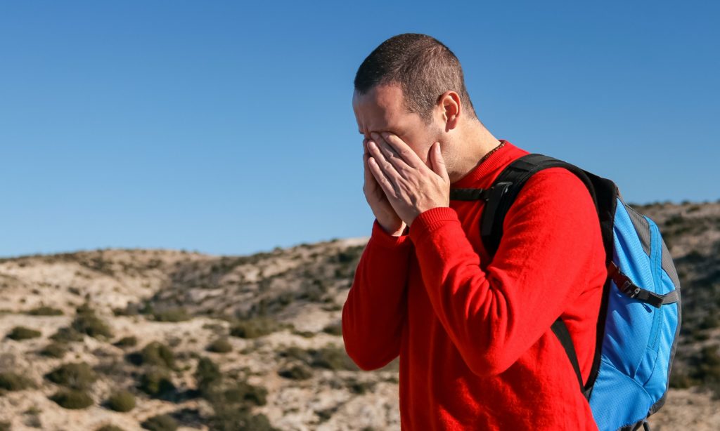 man holding face outdoors