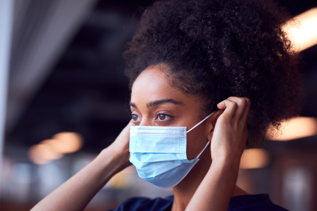 woman putting on face mask