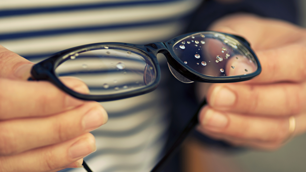 someone holding glasses with water droplets on them