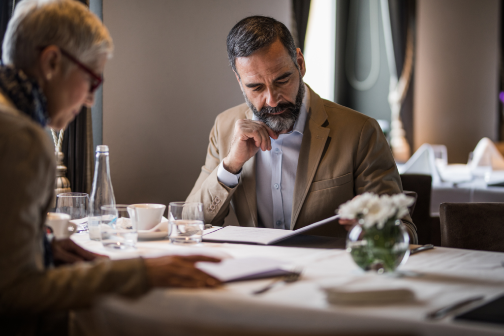 older couple reading menus in restaurant