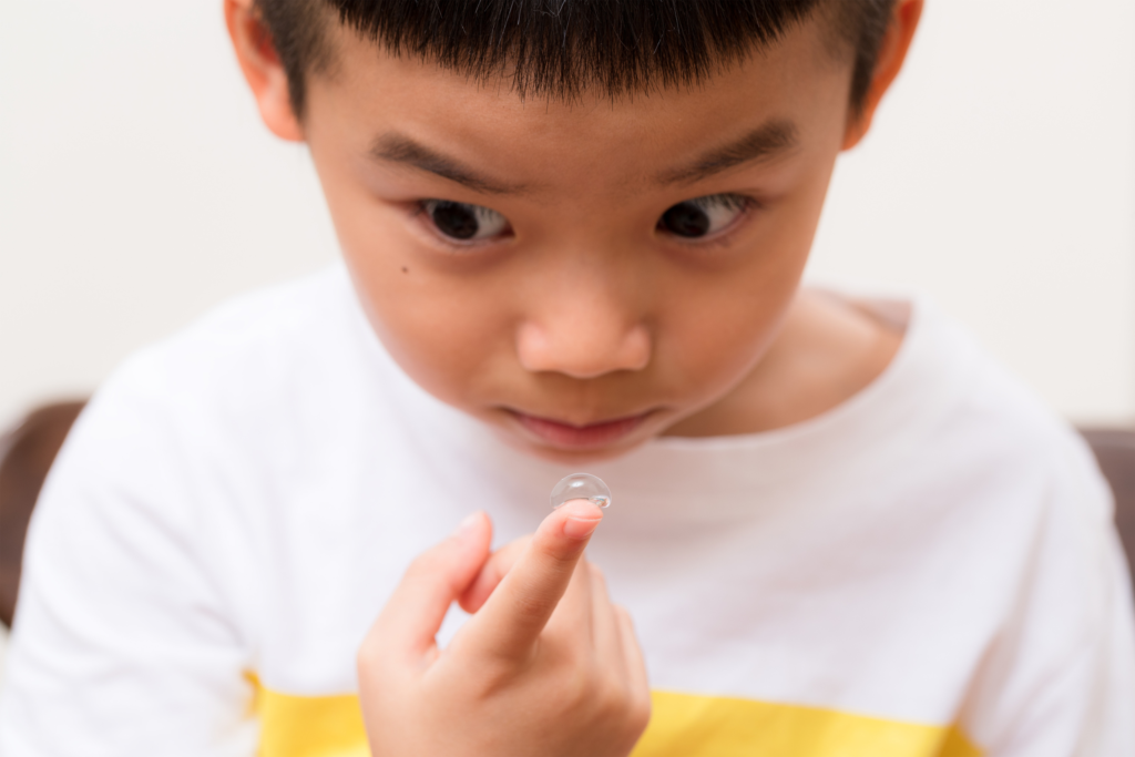 young boy holding contact lens